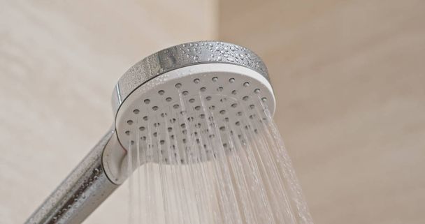 Flujo de agua del cabezal de ducha en el baño
 - Foto, imagen