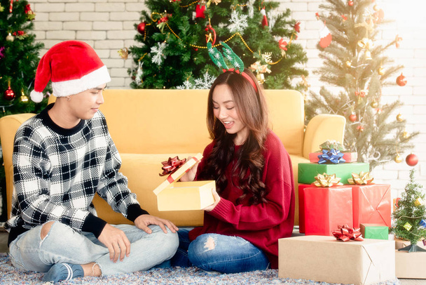 the girl is opening a gift on Christmas's day. - Photo, image