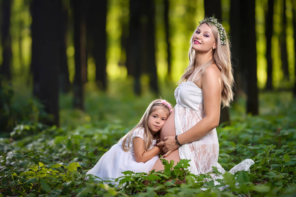 Pregnant woman and her elder daughter outdoor - Фото, зображення