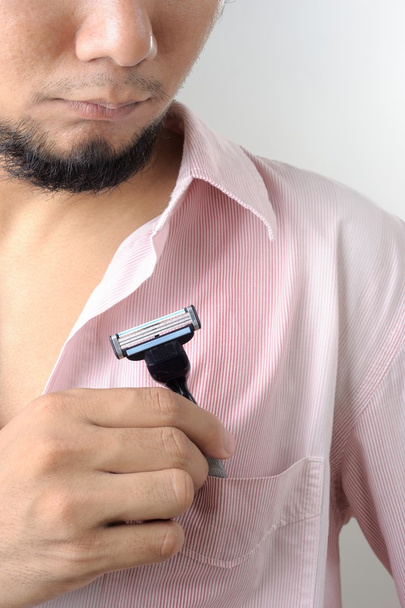 mies laittaa partaveitsi taskuun
 - Valokuva, kuva