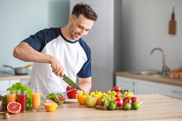 Pohledný muž se zdravými výrobky, který vaří v kuchyni. Koncepce ztráty váhy - Fotografie, Obrázek