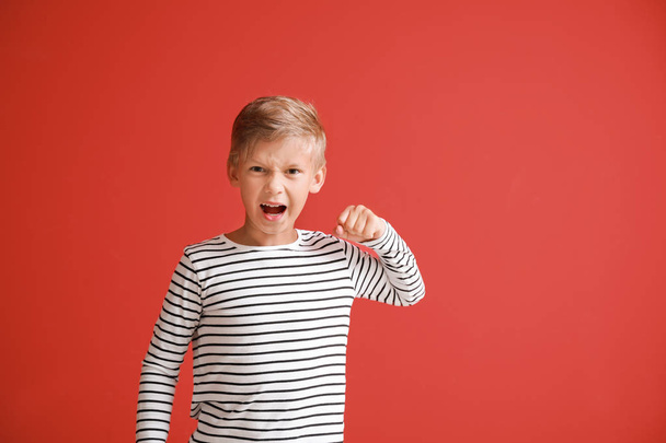 Portrait of angry little boy on color background - Photo, Image