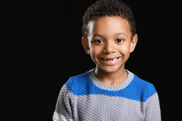 Ευτυχισμένο Αφρο-Αμερικάνικο αγόρι σε σκοτεινό φόντο - Φωτογραφία, εικόνα