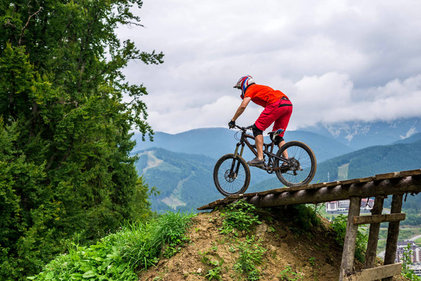 Mężczyzna rowerzysta jazda na rowerze górskim w pięknej przyrody: góry i błękitne niebo. - Zdjęcie, obraz
