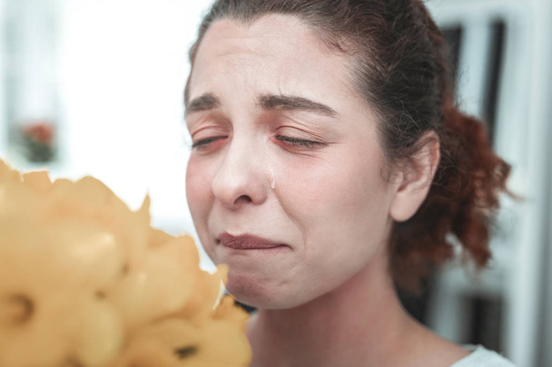 Curly housewife having tears because of allergy to flowers - Foto, Imagem
