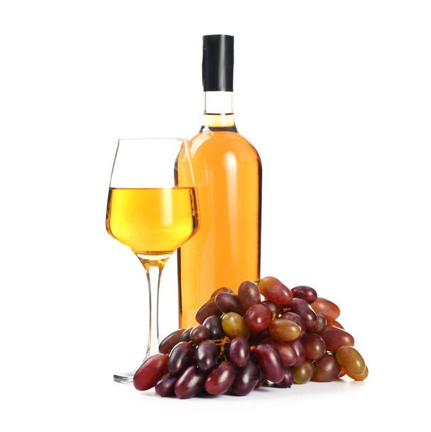 Üveg és pohár ízletes bor fehér alapon, szőlővel - Fotó, kép
