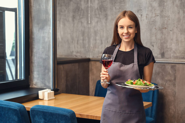 Официантка с бокалом вина и блюд в ресторане
 - Фото, изображение