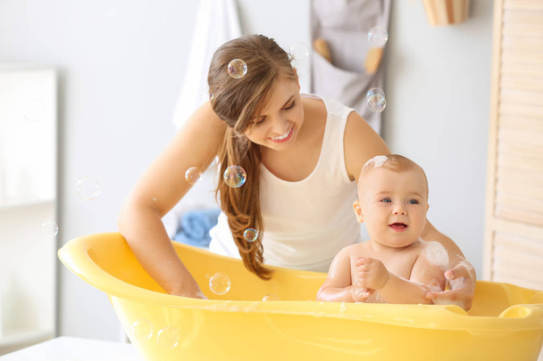 Madre bañando a su lindo bebé en casa
 - Foto, Imagen