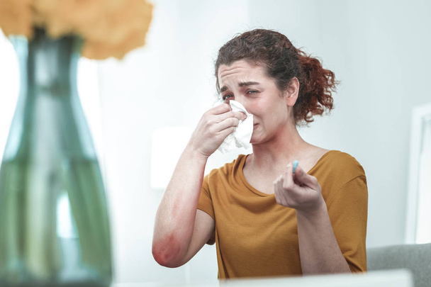 Woman wearing orange shirt drying nose suffering from allergy - Fotoğraf, Görsel