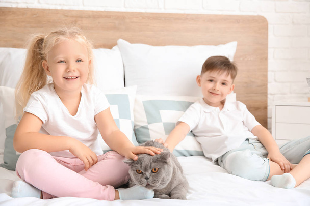 Kleine Kinder mit süßer Katze im Schlafzimmer - Foto, Bild
