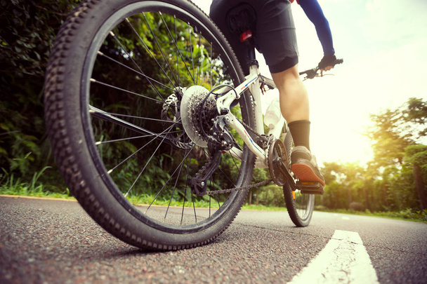 Woman cyclist riding mountain bike on bike path - Valokuva, kuva