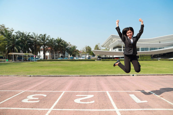 Business competition: businesswoman jumping with hand, meaning of winner - Photo, Image