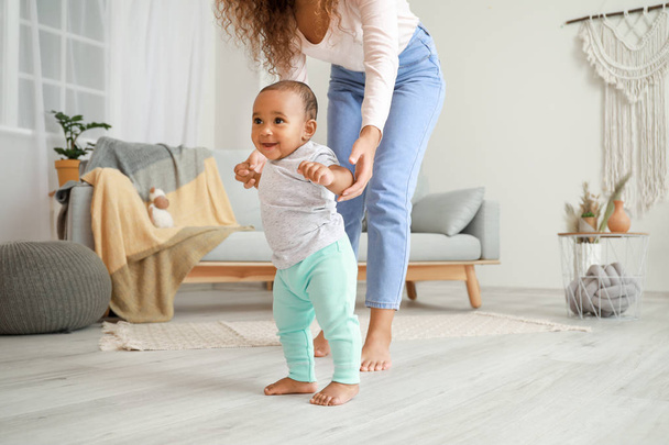 African-American mother teaching her little baby to walk at home - Zdjęcie, obraz
