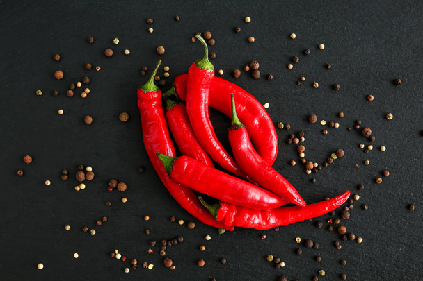 Hot chili peppers and peppercorn on dark background - Φωτογραφία, εικόνα