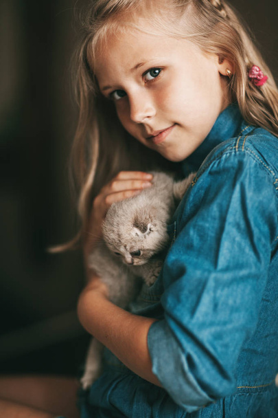 Girl hugs and plays a british little kitten - Фото, изображение