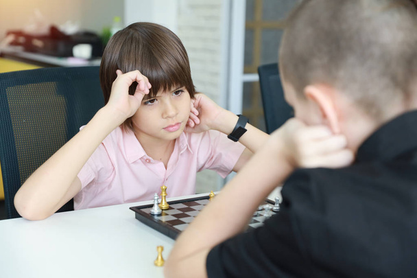 crianças fofas e inteligentes jogando xadrez em sala de aula
 - Foto, Imagem
