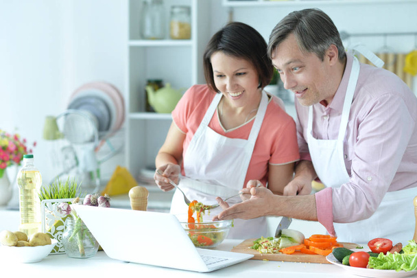 Happy husband and wife cooking together in the kitchen  - 写真・画像