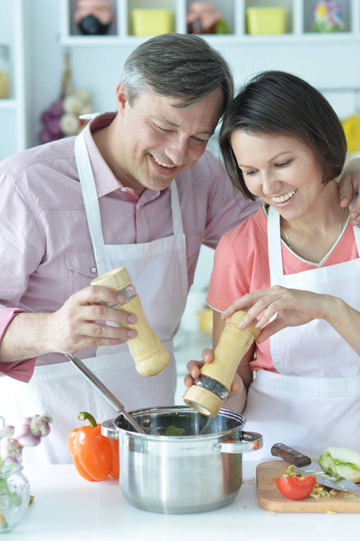 Happy husband and wife cooking together in the kitchen  - Photo, image