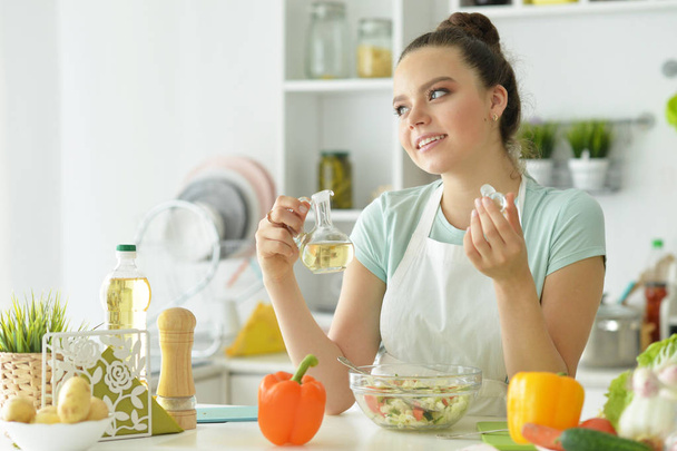 beautiful young woman making  salad   in kitchen - Photo, image
