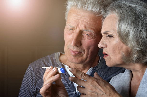 ill Senior couple portrait with thermometer - Φωτογραφία, εικόνα