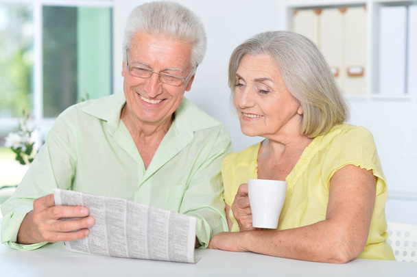 senior couple sitting at table and reading newspaper - Photo, Image