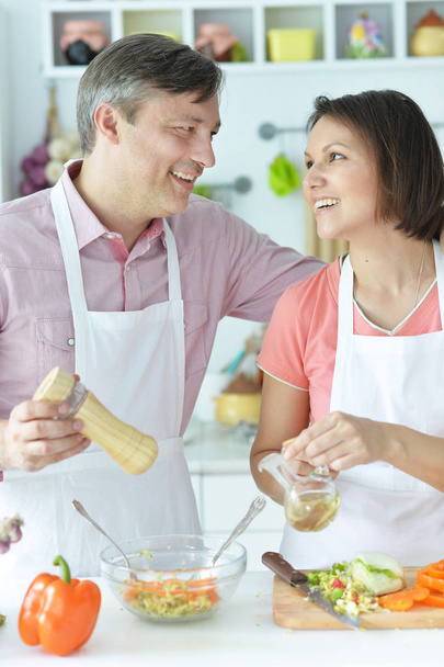 Happy husband and wife cooking together in the kitchen  - Photo, Image