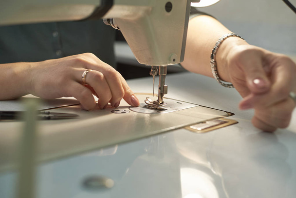 女性が電気ミシンで縫う. - 写真・画像