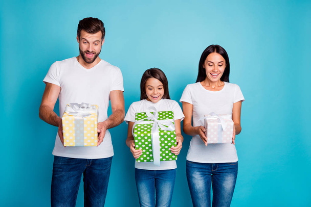 Adopted family holding new year giftboxes overjoyed by large size wear casual outfit isolated blue background - Foto, Bild