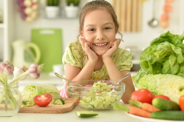 söpö tyttö syö salaattia keittiössä - Valokuva, kuva