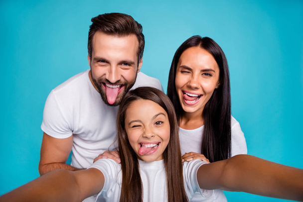 Carefree daddy mommy and small lady making funky selfies wear casual outfit isolated blue background - Foto, Bild