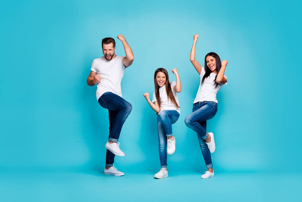 Full body photo of daddy mommy and small lady raising fists air rejoicing wear casual outfit isolated blue background - Foto, Imagen