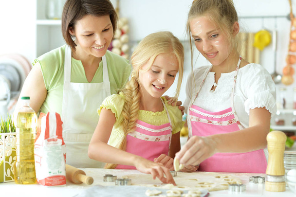 Cute  girls and mother  baking  in the kitchen  at home - Fotó, kép