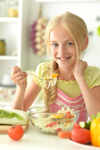 cute girl eating salad  on kitchen - Valokuva, kuva