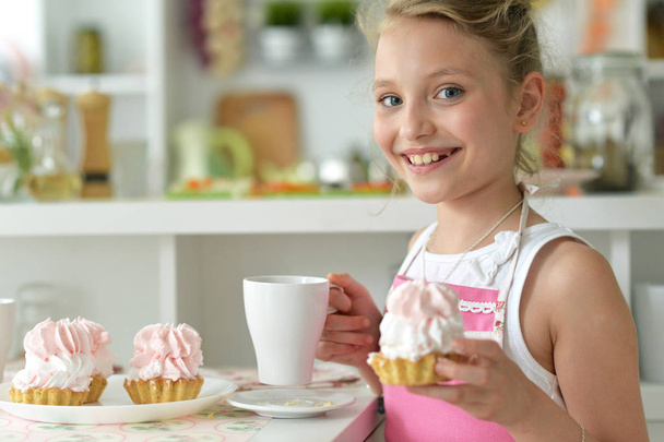 young girl eating cupcakes   in the kitchen - Fotoğraf, Görsel