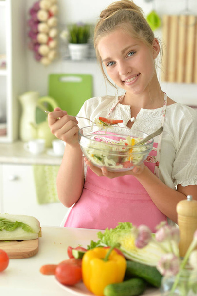 cute girl eating salad  on kitchen - Foto, Imagen