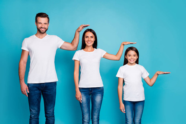 Portrait of charming family holding palm wearing white t-shirt denim jeans isolated over blue background - Foto, Imagem