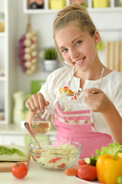cute girl cooking salad  on kitchen - Zdjęcie, obraz