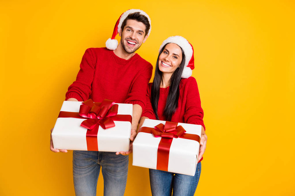 Portrait of two lovely people spouses give present for new year enjoy wear red pullover denim jeans isolated over yellow background - Photo, Image