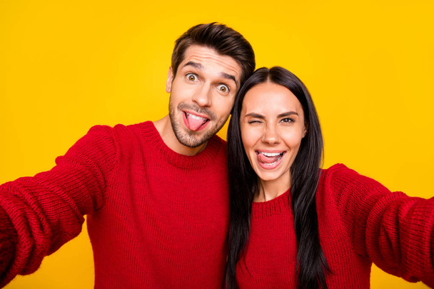 Close up photo of cheerful spouses grimace take self portrait wear red sweater isolated over yellow background - Fotoğraf, Görsel