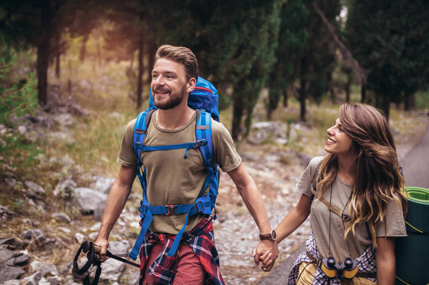Romantic couple hiking trought forest. - Zdjęcie, obraz