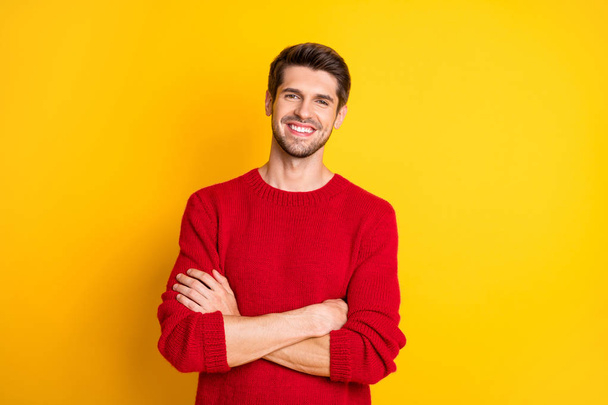 Portrait of charming man with his hands crossed wear red jumper isolated over yellow background - Foto, afbeelding