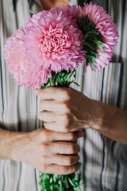 Man holds  bouquet of pink chrysanthemums - Foto, Imagen