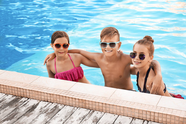 Happy children in swimming pool on sunny day - Photo, Image