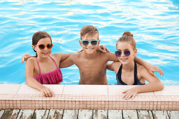 Happy children in swimming pool on sunny day - Photo, Image