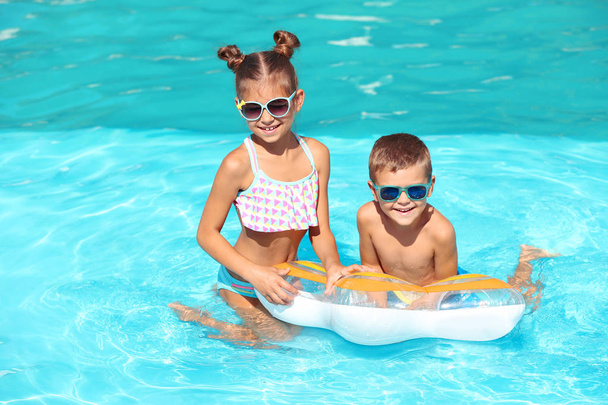 Милі маленькі діти з надувним кільцем у басейні
 - Фото, зображення