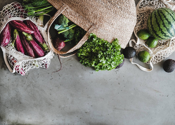 Eco-friendly lifestyle. Flat-lay of of grocery jute and net bags with fresh organic vegetables, greens, fruit from local farmers market, copy space. Zero waste, healthy, vegan and clean eating concept - Fotoğraf, Görsel