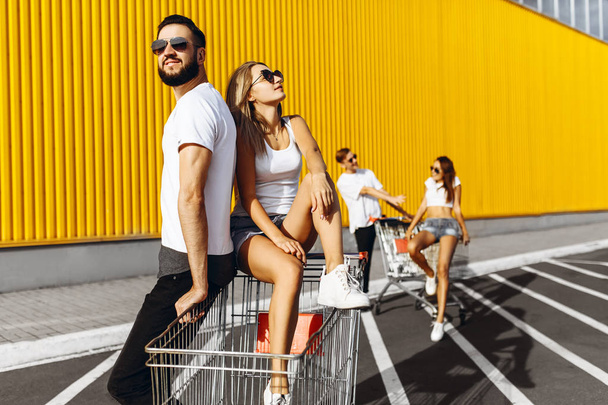 A group of happy young people, having fun on shopping carts, rid - Photo, image