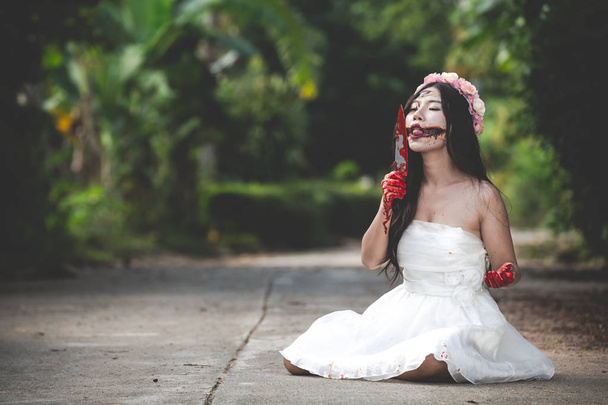 Un fantasma femenino o un zombi con un vestido blanco con una h sangrienta
 - Foto, imagen