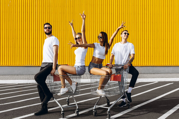 A group of happy young people, having fun on shopping carts, rid - Fotoğraf, Görsel
