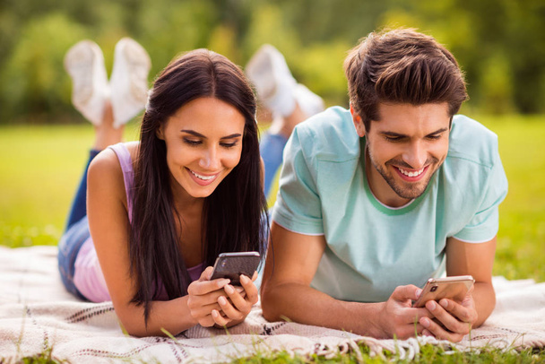 Close-up portrait of her she his he nice attractive lovely charming cute concentrated cheerful cheery best friends spending free time on fresh air using 5g app lying on veil cover outside - Fotoğraf, Görsel